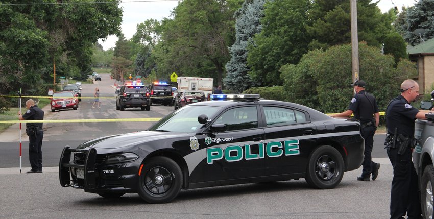 Englewood police cars and officers respond on Thursday to a crash between a suspect's car and a parked vehicle near West Kenyon Avenue and South Galapago Street. The driver fled Sheridan police after a traffic stop a few blocks north.